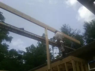 Carpenter setting a ridge beam over a new addition frame in Saint Inigoes