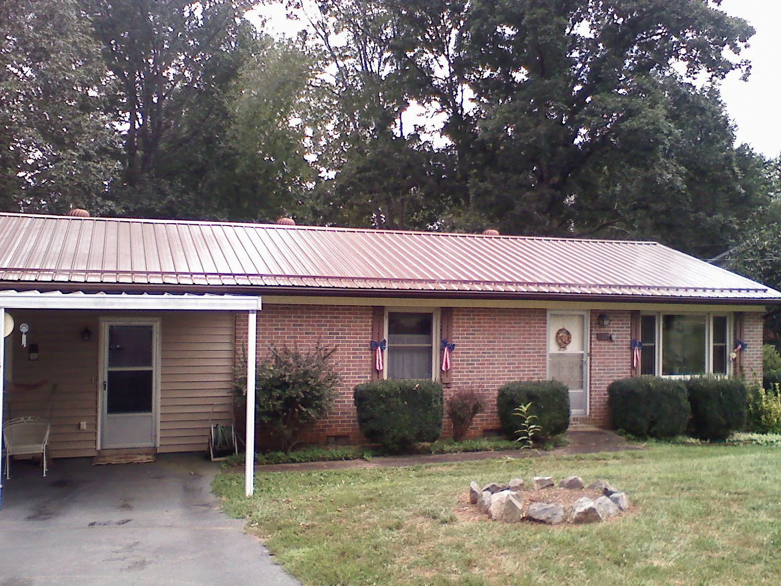 Bronze metal roof and carport on a brick ranch home — Roof Repair work by our crew in Saint Inigoes
